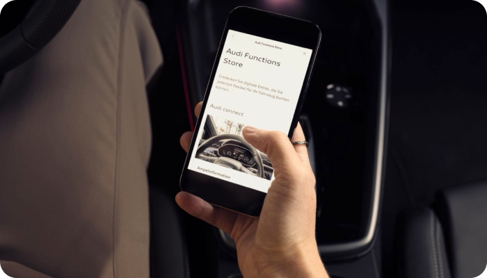 top view of person's hand holding a smartphone inside a car